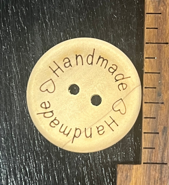1 inch wooden button, two hole, ‘Handmade’ written twice