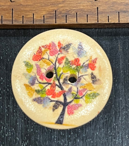 1 1/8 inch round wooden button with two holes. Butterfly tree
